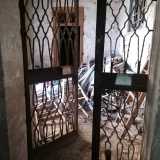 Saliamo la prima rampa e, attraverso una porta in ferro giungiamo in un vano voltato, pieno di materiale edilizio...